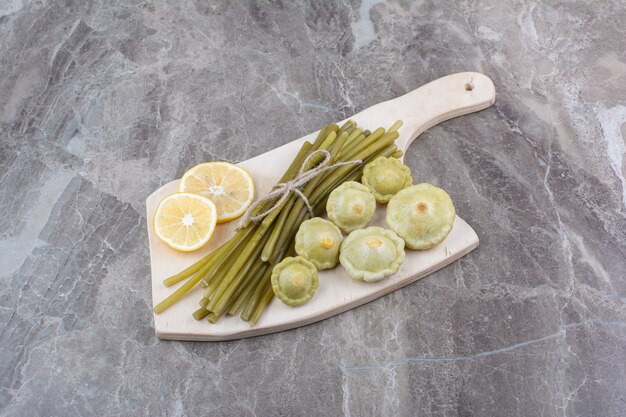 Varias verduras en escabeche sobre tabla de madera.