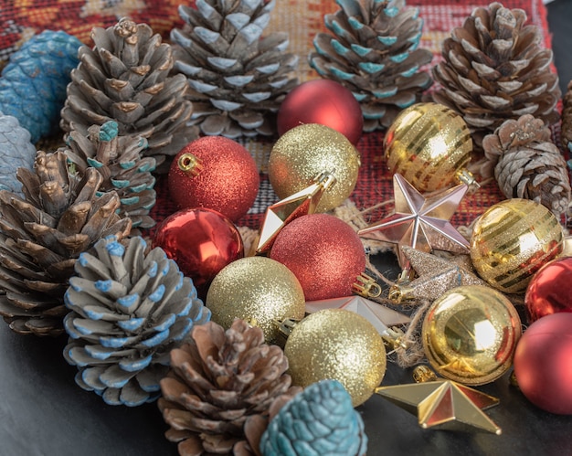 Variedad de adornos para árboles de Navidad en un trozo de alfombra étnica de patrón rojo