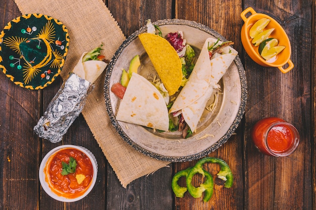 Foto gratuita variedad de comida mexicana con sombrero en mesa de madera