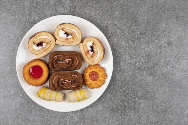 Variedad de deliciosas galletas en plato blanco