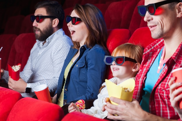 Una variedad de emociones humanas de amigos sosteniendo una cola y palomitas de maíz en el cine.