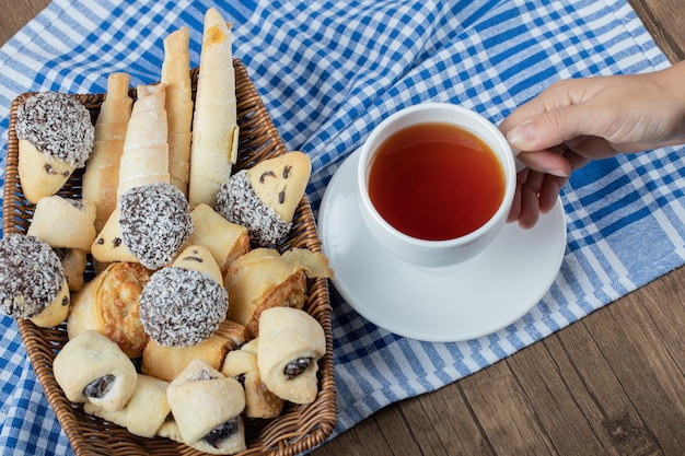 Foto gratuita variedad de galletas en bandeja con una taza de té a un lado.