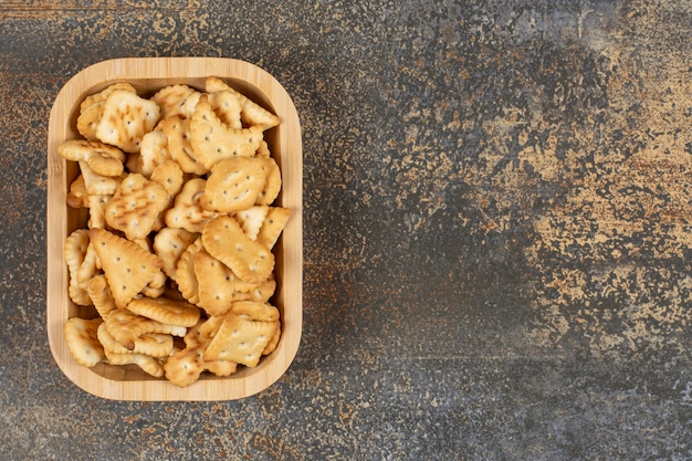 Variedad de galletas saladas en tazón de madera.