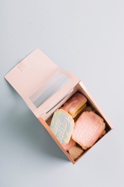 Variedad de galletas con el texto del feliz cumpleaños en la caja de regalo aislada en el fondo blanco
