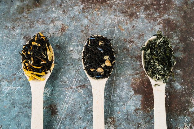 Variedad de hierbas de té en cucharas vista superior