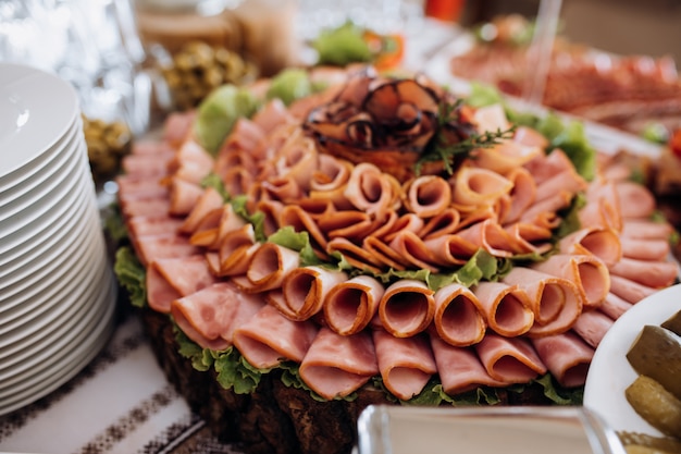 Variedad de jamón loncheado y decorado con ensalada.