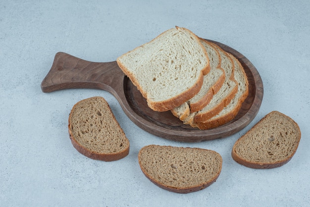 Variedad de rebanadas de pan sobre tabla de madera