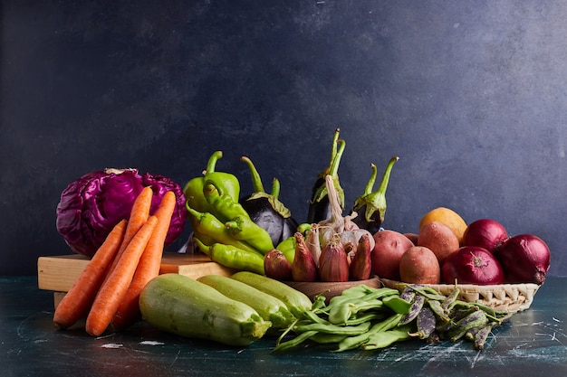 Variedad de vegetales aislados en mesa azul.