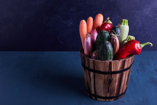 Variedad de verduras en un balde rústico.