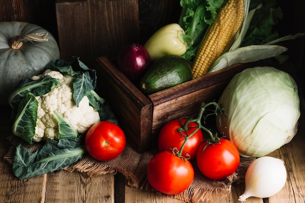 Variedad de verduras y una canasta de madera.