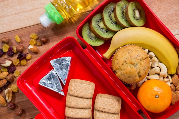 Varios de aperitivos, fruta y aceite de mesa de madera