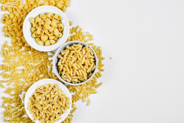 Varios cuencos de pasta cruda en blanco