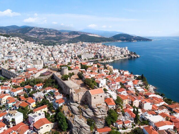 Varios edificios y fuertes colinas verdes en el fondo en Kavala, Grecia