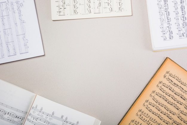 Varios libros de notas musicales sobre fondo blanco con espacio para texto