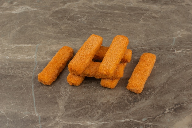 Varios nuggets de pollo sobre mesa de mármol.