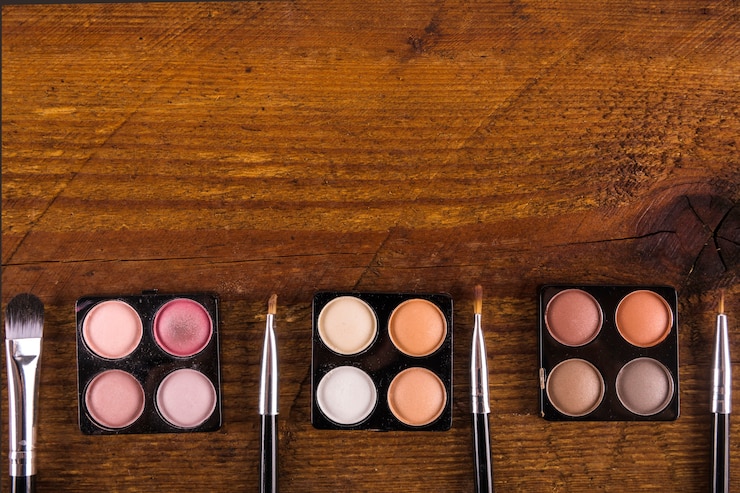 Foto gratuito varios pinceles de maquillaje y polvos de sombra de ojos de colores sobre fondo de madera