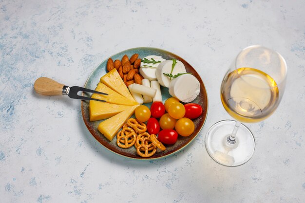 Varios platos de queso y queso en la mesa de luz con diferentes nueces y frutas