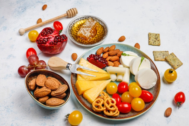 Varios platos de queso y queso en la mesa de luz con diferentes nueces y frutas