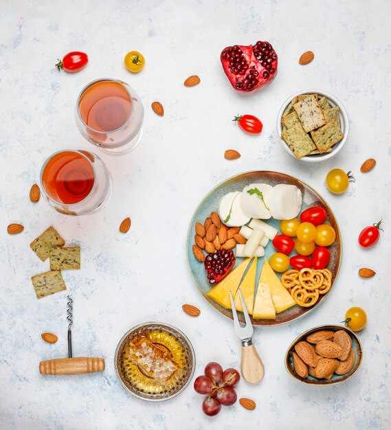 Varios platos de queso y queso en la mesa de luz con diferentes nueces y frutas