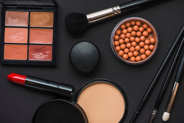 Varios productos de maquillaje en fondo negro