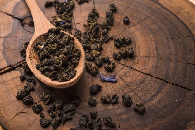 Varios de té seco sobre fondo de tocón de árbol de madera