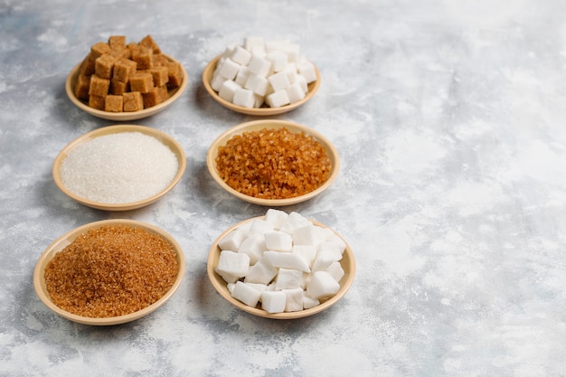 Varios tipos de azúcar, azúcar moreno y blanco sobre hormigón, vista superior