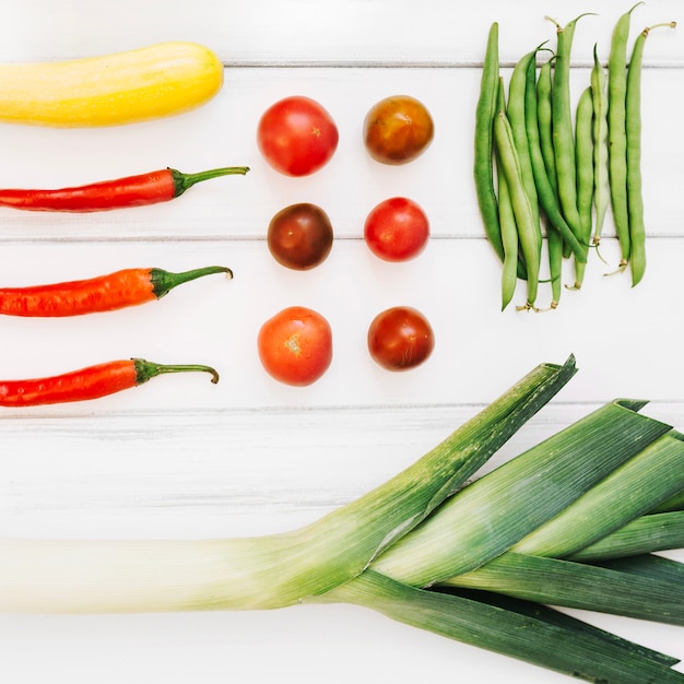 Varios vegetales en la mesa de madera blanca