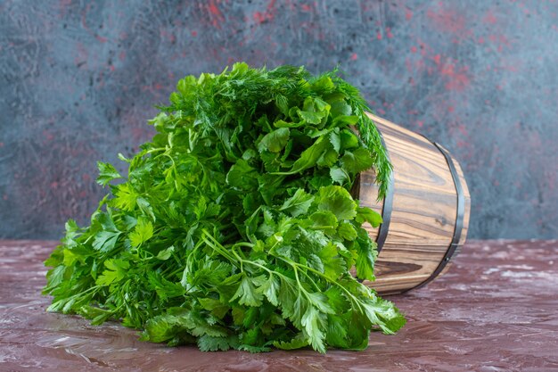 Varios verdes en un balde, sobre el fondo de mármol.