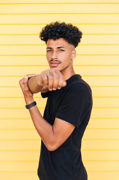 Foto gratuita varón étnico joven que estira los brazos