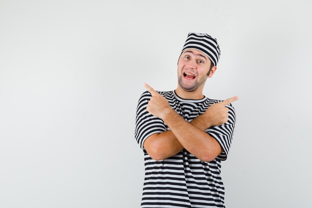 Varón joven en camiseta, sombrero apuntando hacia afuera y mirando alegre, vista frontal.