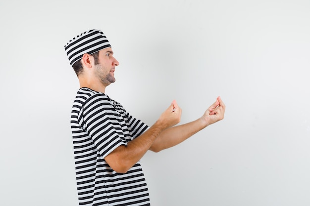 Foto gratuita varón joven en camiseta, sombrero haciendo gesto italiano, disgustado con una pregunta tonta.