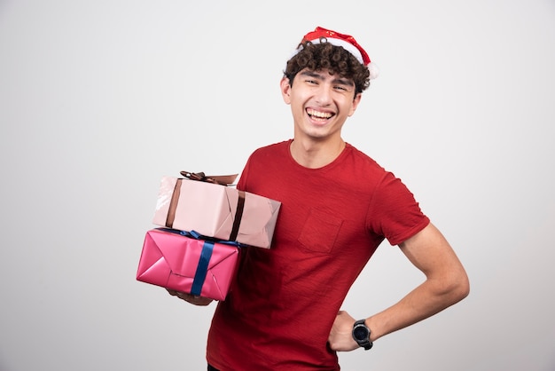 Varón joven con gorro de Papá Noel con regalos