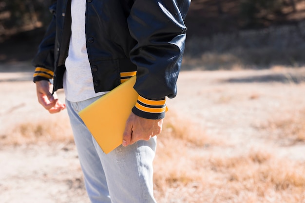 Foto gratuita varón joven con libro amarillo en la mano