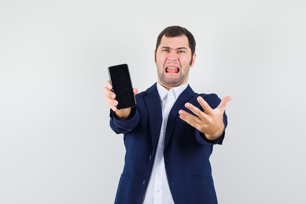 Varón joven mostrando teléfono móvil en camisa