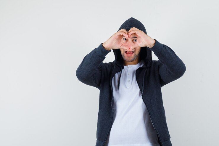 Foto gratuito varón joven que muestra el gesto del corazón en camiseta, chaqueta y mirando confiado, vista frontal.