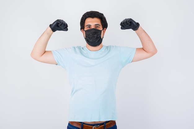 Foto gratuita varón joven que muestra el gesto del ganador en la camiseta y parece afortunado, vista frontal.