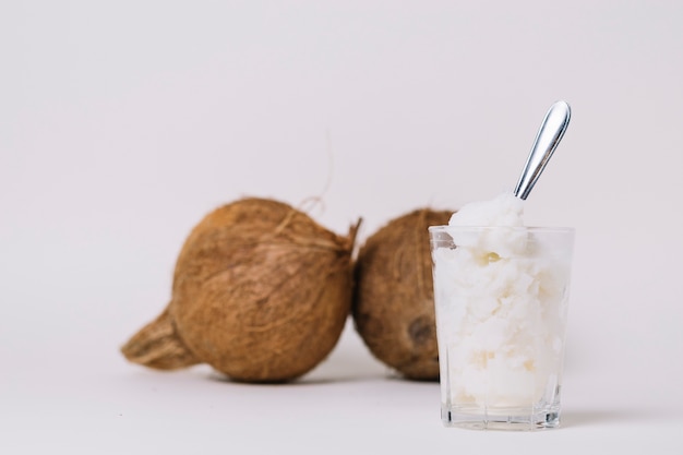 Vaso de aceite de coco con nueces de coco