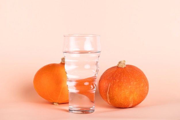 Vaso de agua con calabazas pequeñas