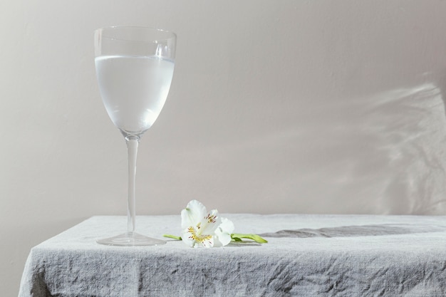 Vaso de agua y flores en la mesa