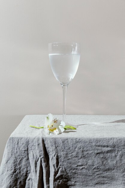 Vaso de agua y flores en la mesa