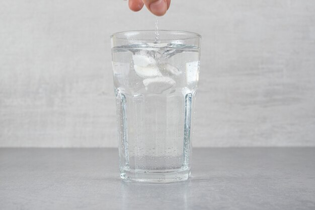 Un vaso de agua fría pura sobre una superficie gris