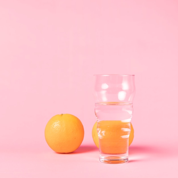 Vaso de agua y fruta de naranja