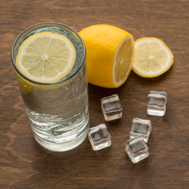 Vaso de agua con hielo y rodaja de limón saludable