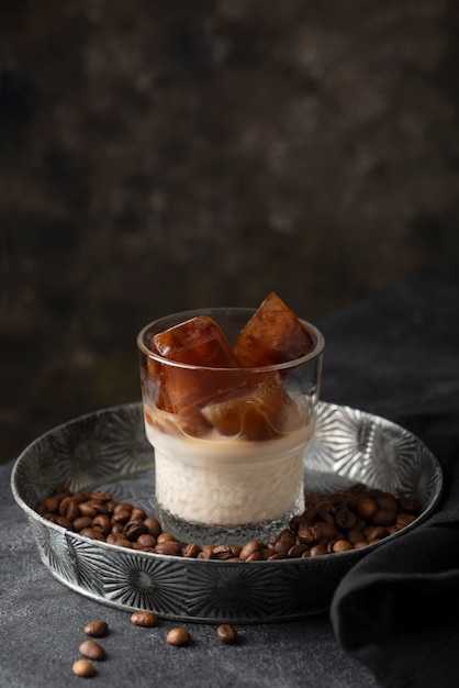 Vaso de ángulo alto con cubitos de hielo de leche y café.