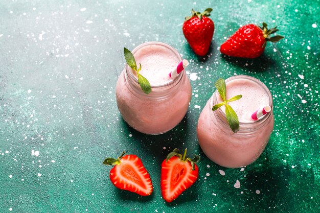 Vaso de batido de fresa fresca, batido y fresas frescas, comida sana y concepto de bebida.