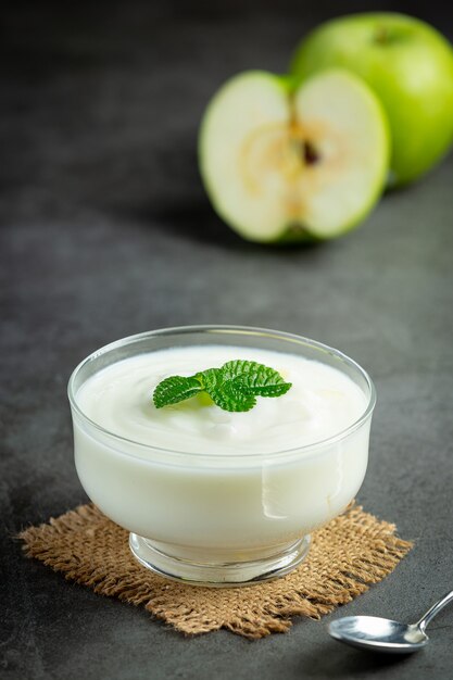 Vaso de batido saludable de manzana verde junto a manzanas verdes frescas