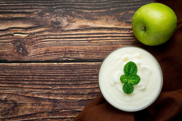 Vaso de batido saludable de manzana verde junto a manzanas verdes frescas