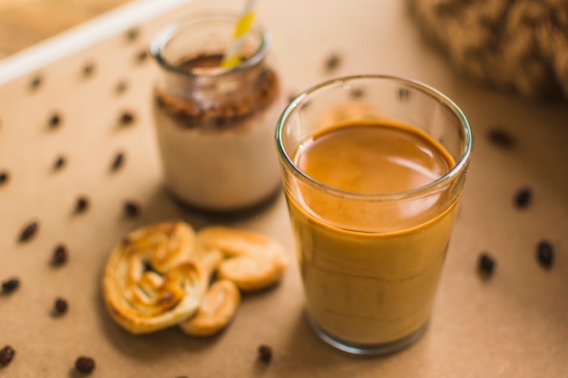 Foto gratuita vaso de bebida cerca de pastelería y pasas