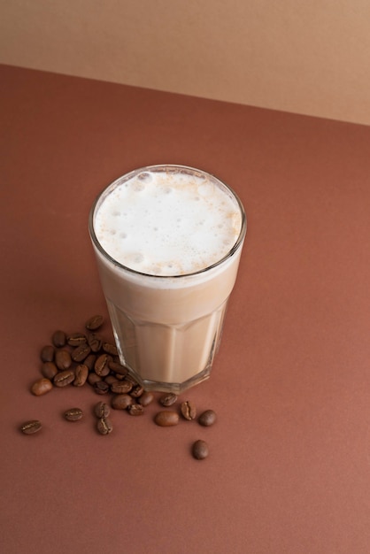 Vaso de café frappé con granos de café al lado