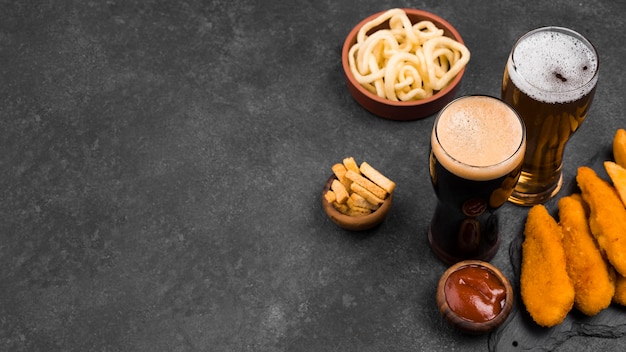 Foto gratuita vaso de cerveza y comida deliciosa de alto ángulo